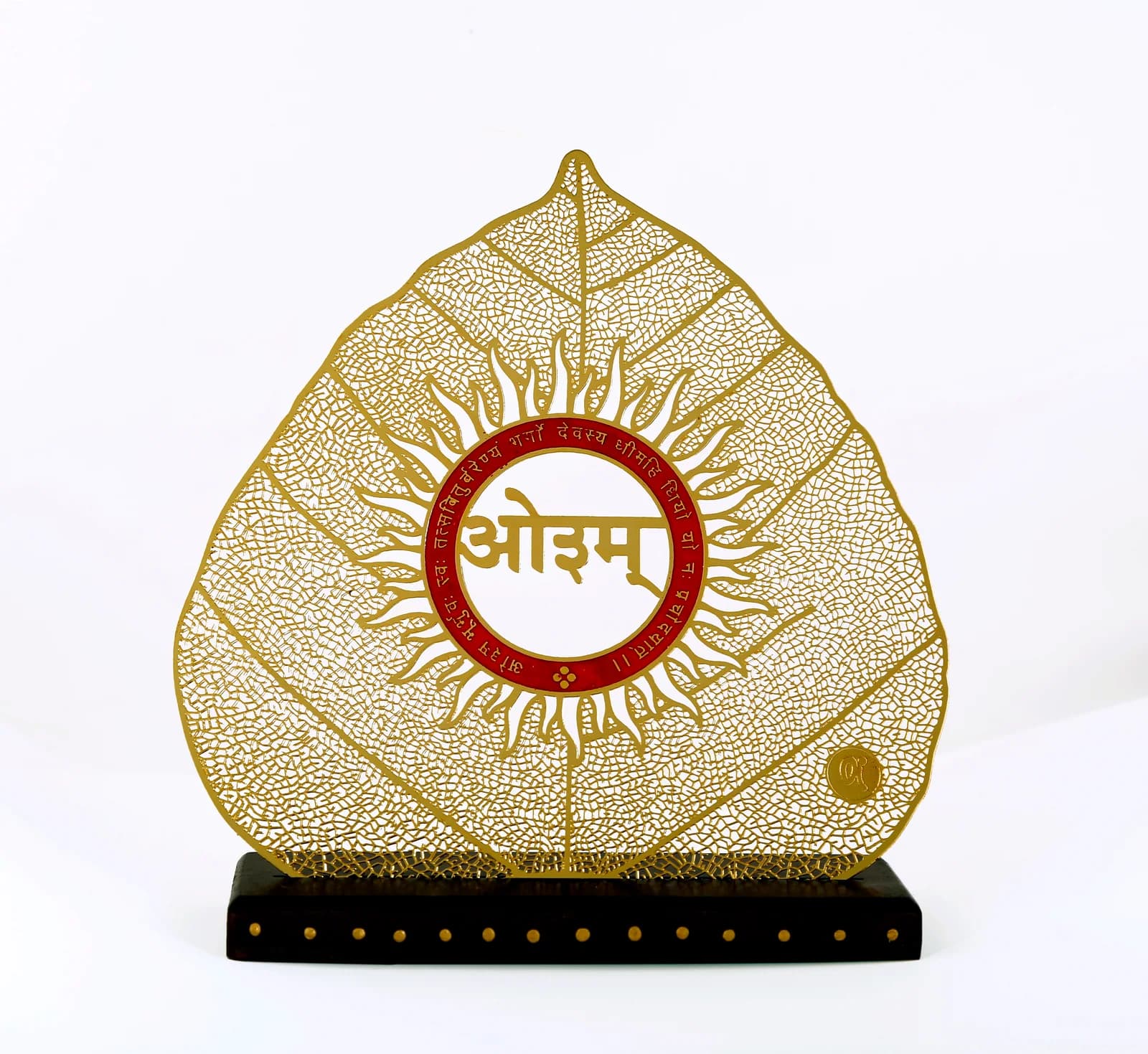 Gold skeletonised bodhi leaf showpiece on a wooden base, engraved with Aum inside a sun and the Gayatri Mantra in red