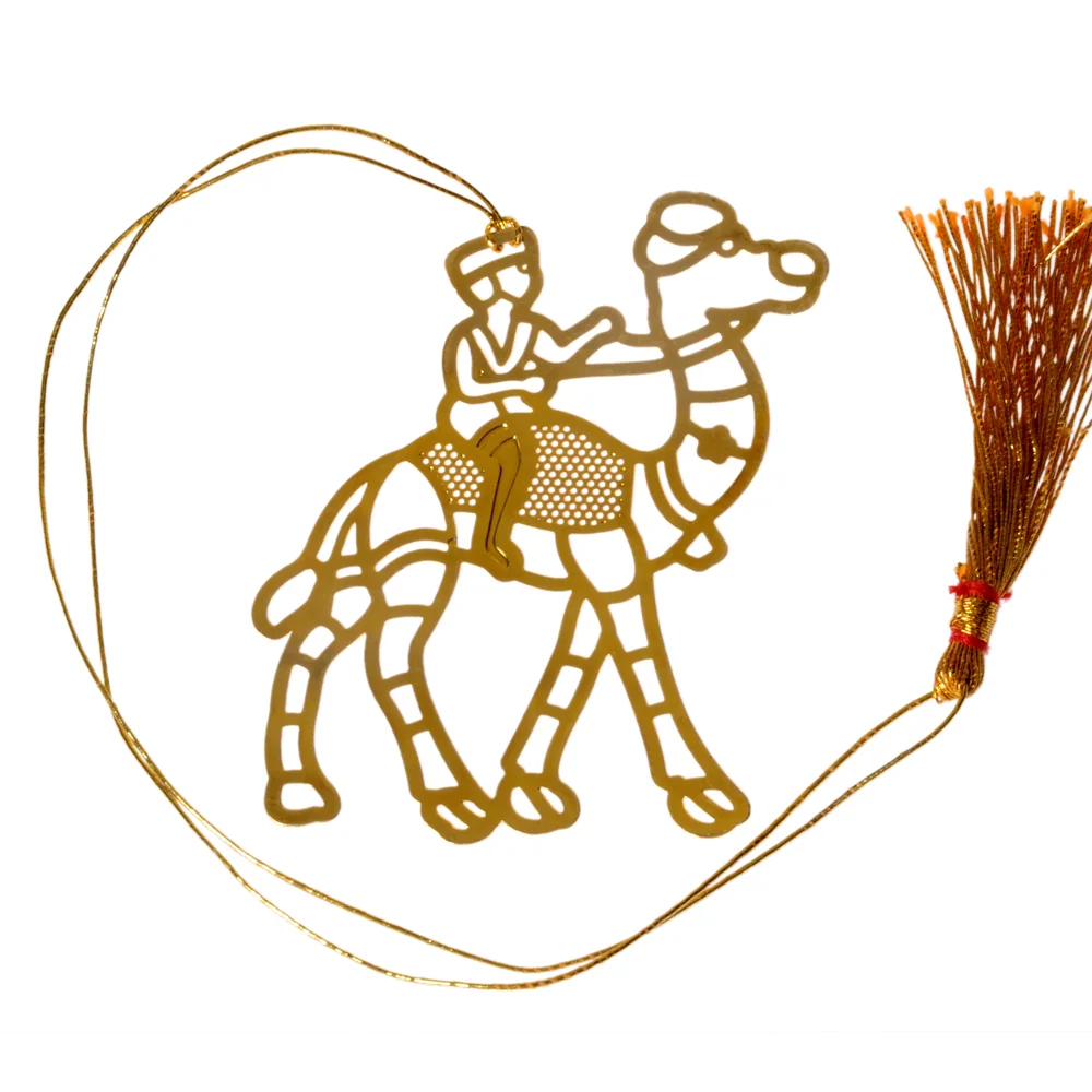 Die-cut gold-tone bookmark of a walking camel with a rider on a lattice saddle blanket, on a gold cord with a tassel