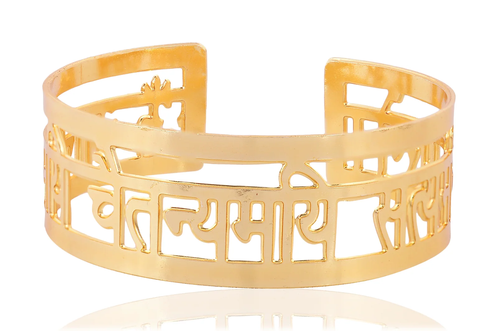 Open gold-plated cuff bangle pierced with a Sanskrit mantra in Devanagari, shot square on at eye level with a trident cut into the narrow upper band