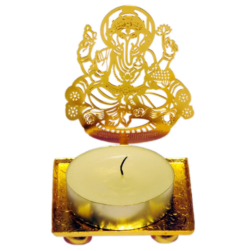 Ganesha shadow diya — a pierced gold-tone metal tealight holder on a square tray
