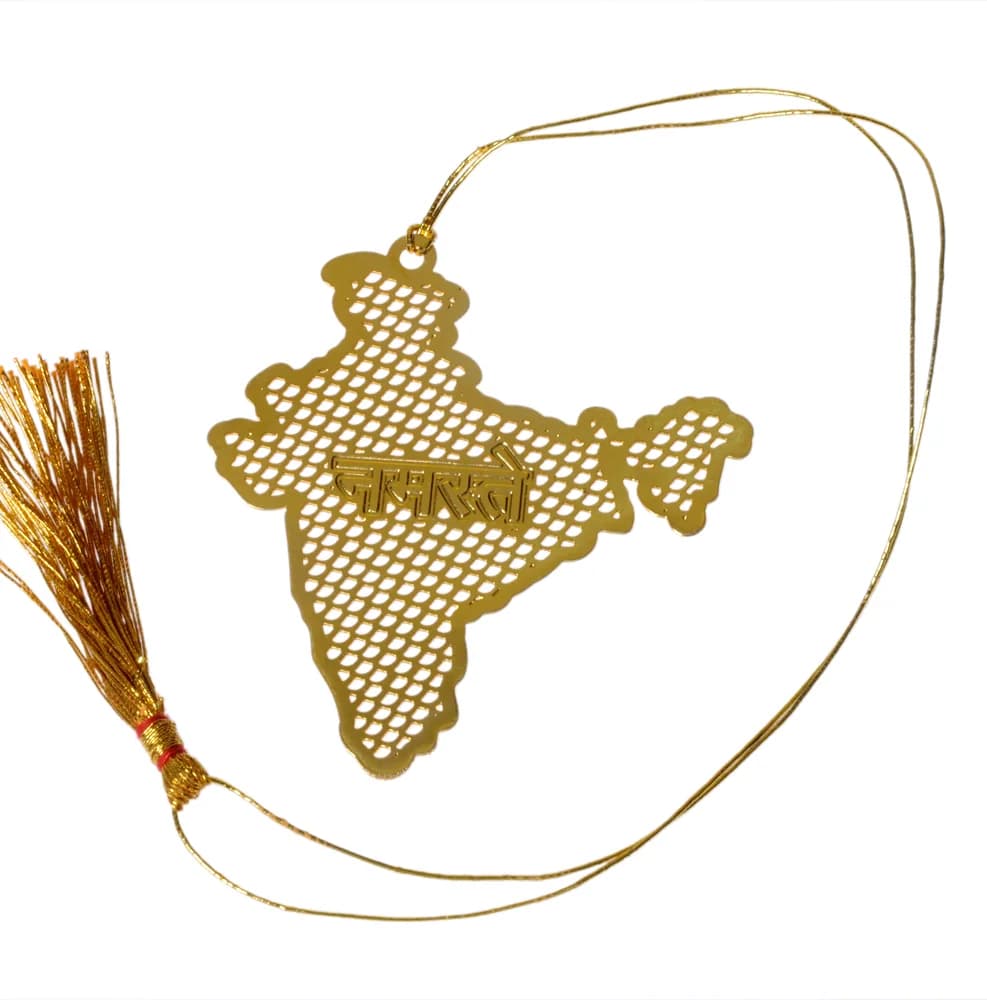 Die-cut gold-tone bookmark shaped as the map of India in pierced diamond lattice, नमस्ते raised across it in Devanagari, on a gold cord with a tassel