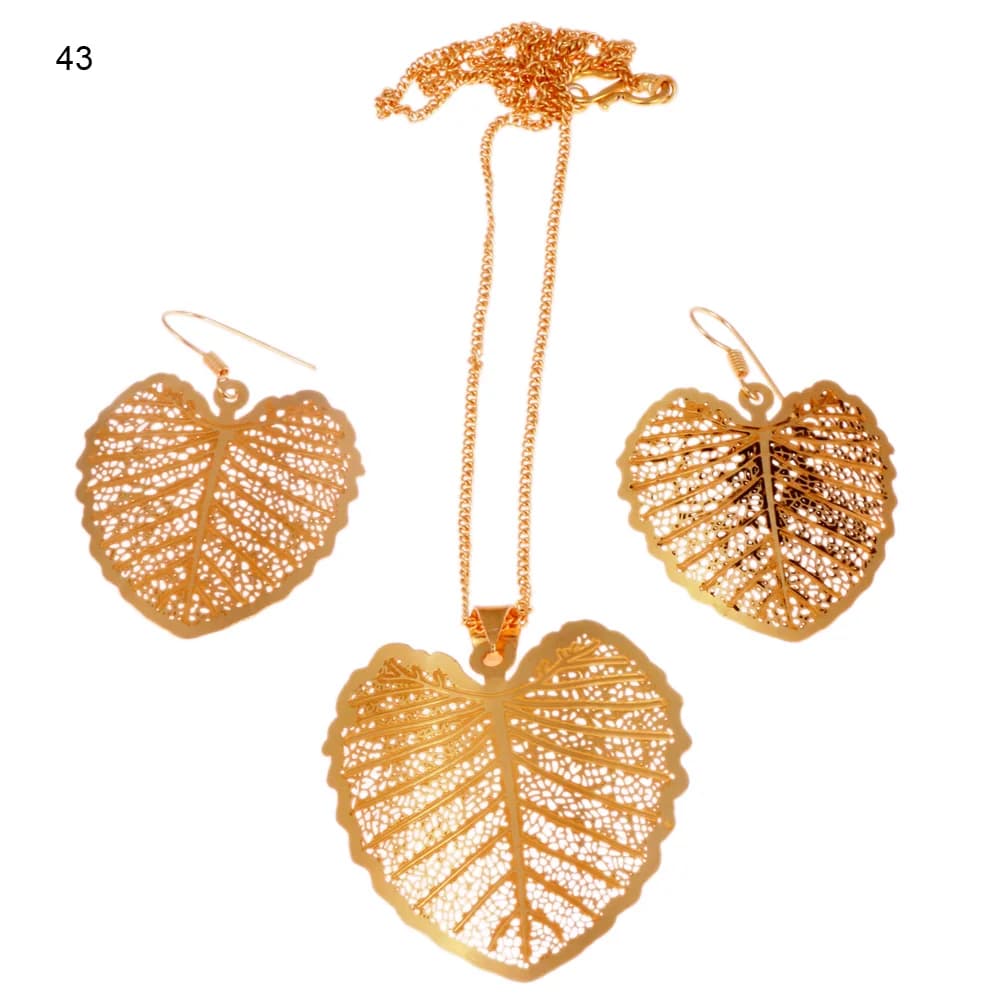 Gold-plated three-piece set with a broad heart-shaped leaf pendant and matching hook earrings, a scalloped rim enclosing heavy ribs laid over an open net