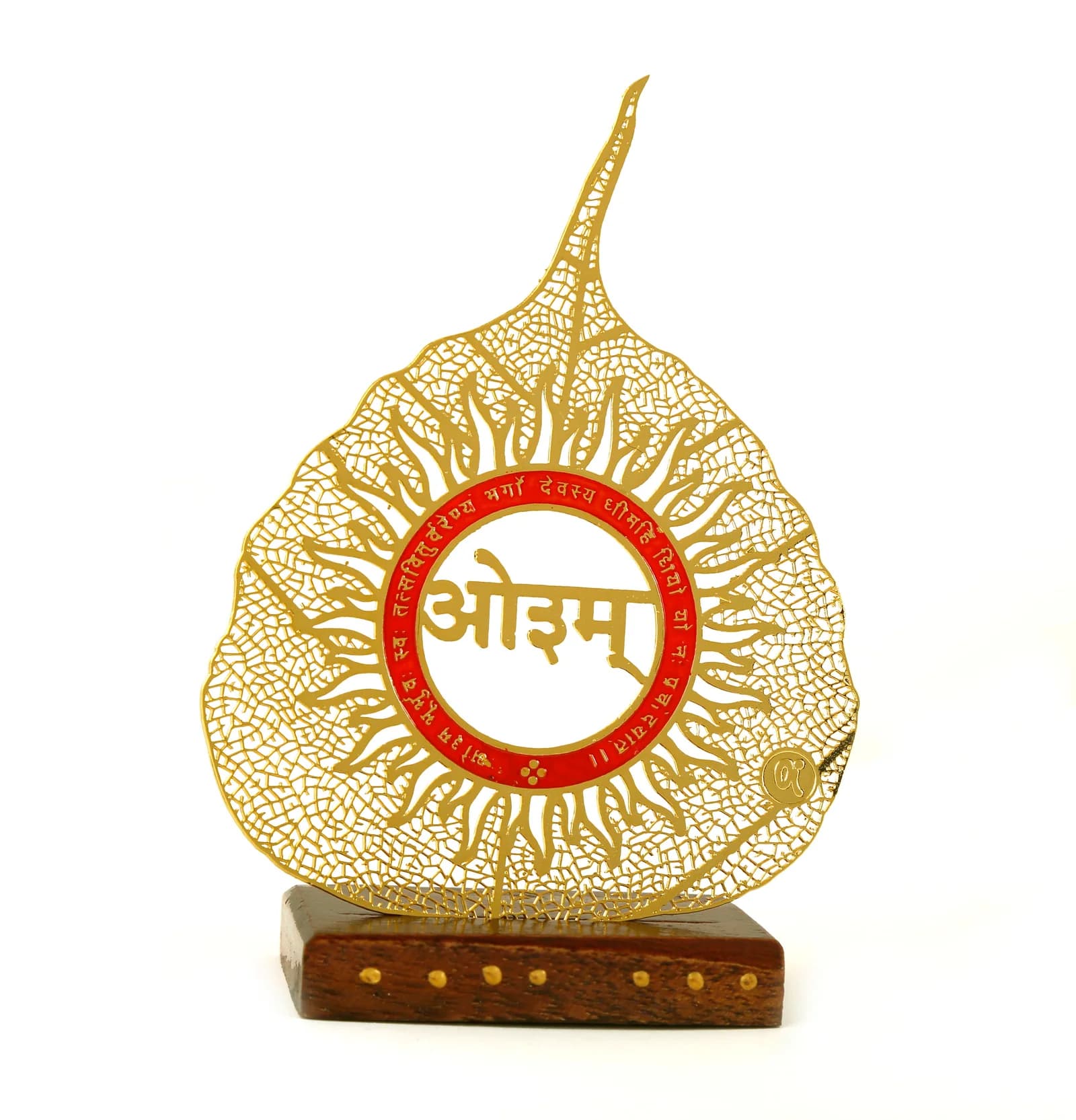 Gold skeletonised peepal leaf with a long drawn tip, carrying Aum inside a sun disc ringed with the Gayatri Mantra in red, on a studded wooden base