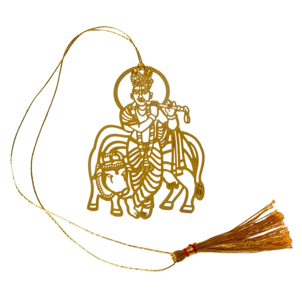 Die-cut gold-tone bookmark of a crowned Krishna playing his flute beside his cow, a halo behind him, on a gold cord with a tassel