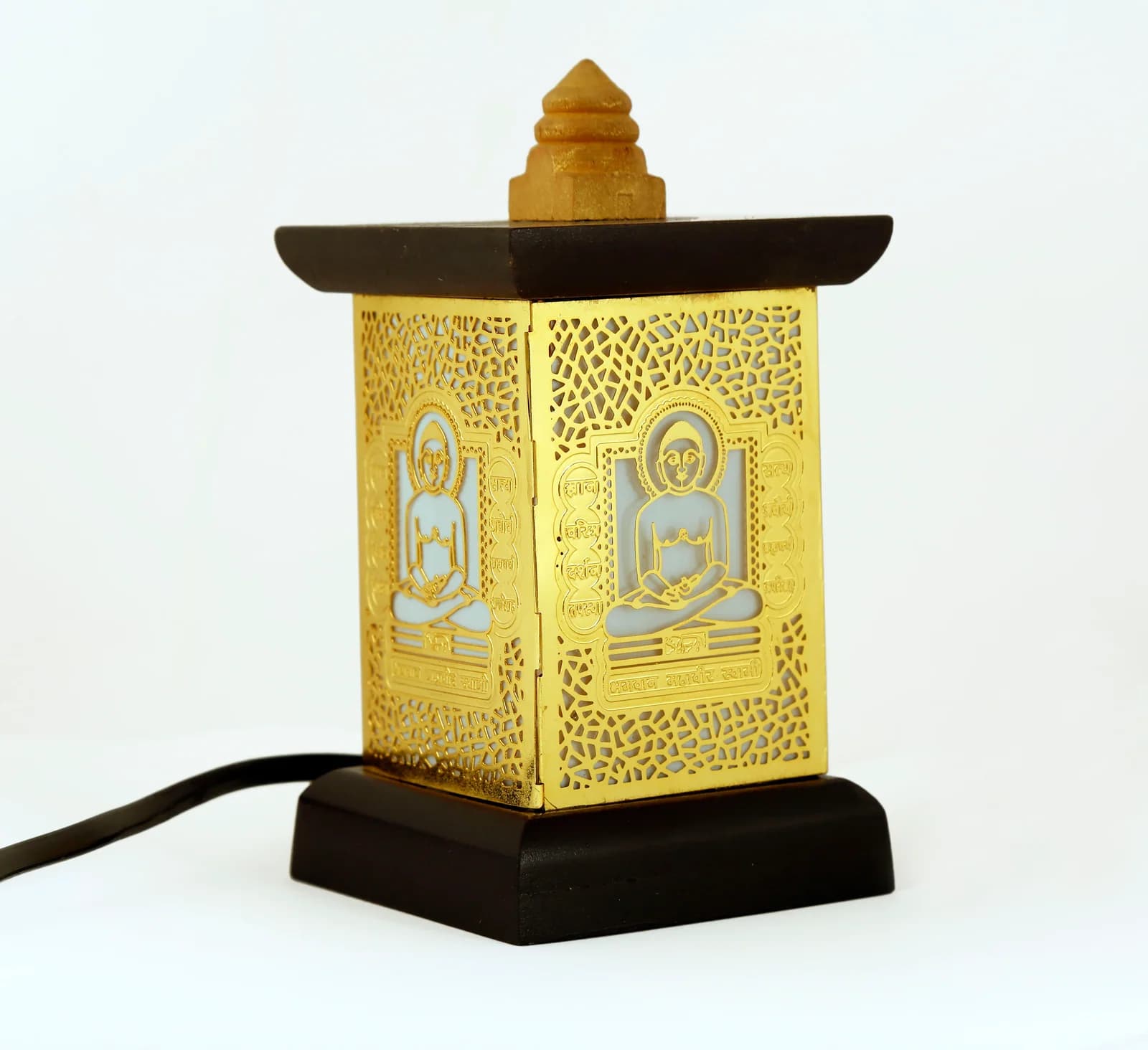 Wooden table lamp with a pierced gold panel of Bhagwan Mahavir Swami seated in padmasana above a lattice ground, unlit on white