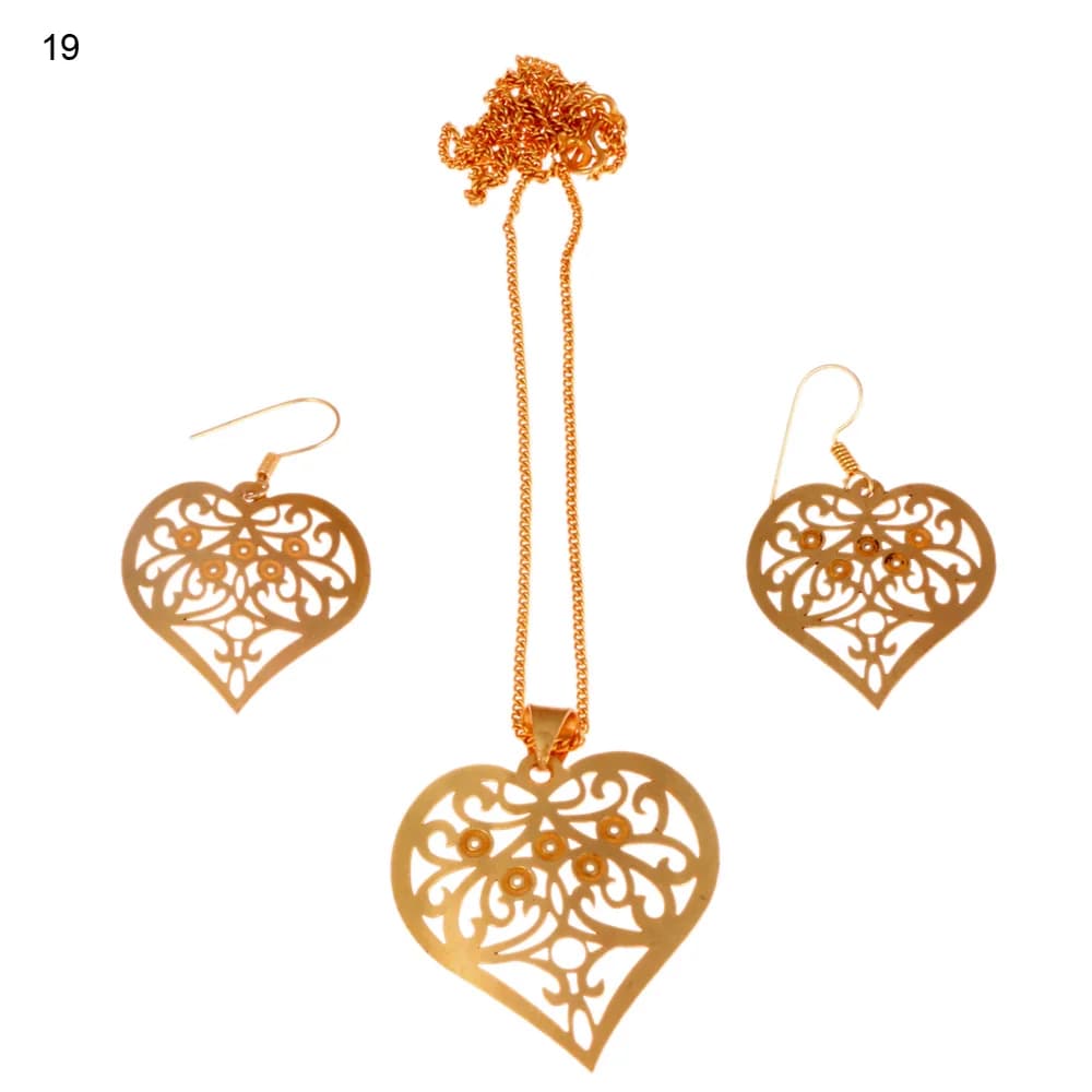 Gold-plated three-piece set with a heart pendant and matching hook earrings, filled with curling scrollwork around five small raised rosettes