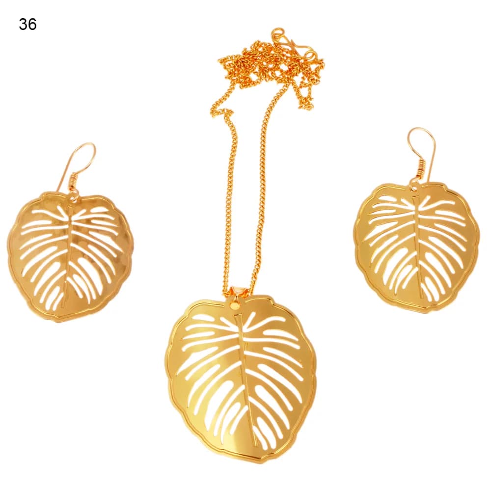 Gold-plated three-piece set with a broad monstera leaf pendant and matching hook earrings, cut from solid sheet with slit veins and a scalloped rim